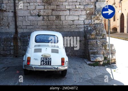 L'iconica auto italiana 'Fiat 500' parcheggiata nel borgo medievale di Gubbio, in Umbria, Italia Foto Stock