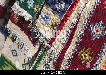Tappeti di lana colorati con ornamenti orientali tradizionali. Foto ravvicinata con una leggera messa a fuoco selettiva presa sul mercato di Tbilisi, Georgia Foto Stock