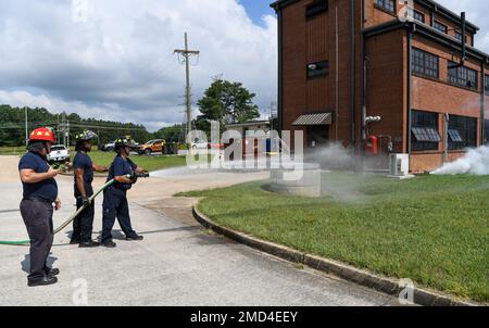 Nel corso di un esercizio guidato dall'Ispettore Generale del complesso Arnold Engineering Development e dal Comandante Wing Inspection Team, dal personale dei servizi antincendio e di emergenza Chavis Lee, centro, vigile del fuoco, e Ken Young, destra, Un paramedico/pompiere, spruzzare acqua per indicare che stanno combattendo un incendio e accelerare la dissipazione di un pennacchio chimico rilasciato a seguito di un'esplosione simulata, il 12 luglio 2022, alla base dell'aeronautica militare Arnold, Tennessee. L'esercizio ha simulato un attacco terroristico sulla base per testare la risposta da parte di varie organizzazioni sulla base. Il fumo visto nella foto era una spe Foto Stock