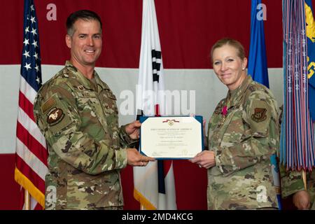 Joshua Wood, comandante dell'ala combattente 51st, presenta il comandante uscente del gruppo di supporto missione Jonelle Eychner, 51st, con la medaglia Legione del merito durante la cerimonia di cambio di comando del 51st all'Osan Air base, Repubblica di Corea, 13 luglio 2022. La medaglia della Legione del merito viene presentata a coloro che hanno svolto il proprio lavoro al di là dei doveri previsti, e che hanno raggiunto risultati eccezionali. Foto Stock