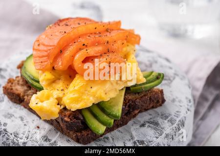 Uova strapazzate con salmone affumicato e pane tostato integrale Foto Stock