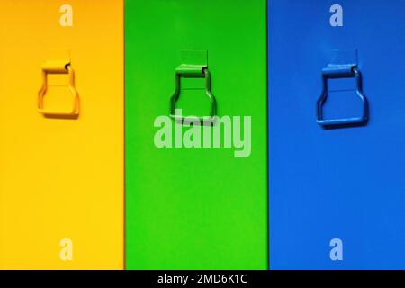 Sportelli per armadi gialli, verdi, di colore blu. Cassetti colorati e maniglie per cassetti. Foto Stock