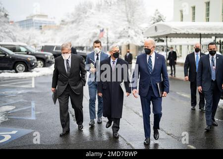 Reportage: Il presidente Joe Biden cammina attraverso West Executive Avenue alla Casa Bianca con gli Stati Uniti Il procuratore generale Merrick Garland, centro, il segretario all'agricoltura Tom Vilsack, a sinistra, e direttore del Consiglio economico nazionale Brian Deese, lunedì 3 gennaio 2022 Foto Stock
