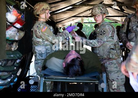 STATI UNITI Quincee Schultz, ha lasciato, una medica di combattimento in addestramento assegnato al Battaglione 173rd Brigade Engineer, Wisconsin Army National Guard, e gli Stati Uniti Danielle Whitsel, a destra, una medica di combattimento in addestramento assegnato alla 7244th Medical Support Unit, Tennessee Army Reserve, prepararsi a trattare un incidente simulato all'interno di una stazione di aiuto battaglione a Stones Ranch Military Reservation, East Lyme, Connecticut, 13 luglio 2022. I medici si dividerebbero in squadre di due persone, controllerebbero le vittime per eventuali ferite, curerebbero e stabilizzerebbero le vittime e le preparerebbero per l'evacuazione sia con aria che con gr Foto Stock