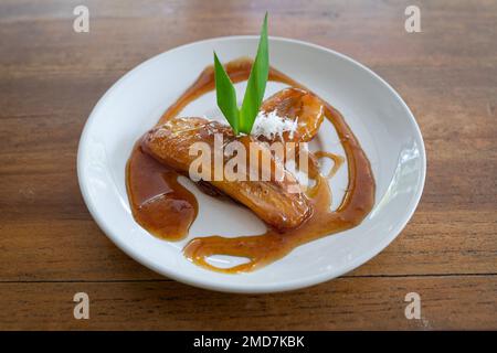 Vista laterale del Balinese Kolak Pisang (piantina o banana in latte di cocco e sciroppo di zucchero) Foto Stock