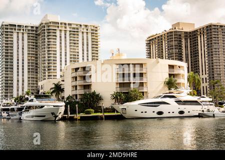 Aventura, Miami, Florida - 22 gennaio 2023: Paesaggio urbano con canale d'acqua, edifici moderni e cieli Foto Stock