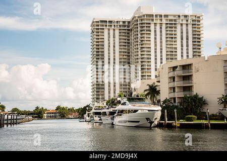 Aventura, Miami, Florida - 22 gennaio 2023: Paesaggio urbano con canale d'acqua, edifici moderni e cieli Foto Stock