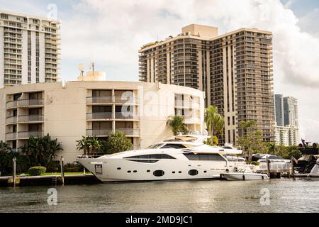 Aventura, Miami, Florida - 22 gennaio 2023: Paesaggio urbano con canale d'acqua, edifici moderni e cieli Foto Stock