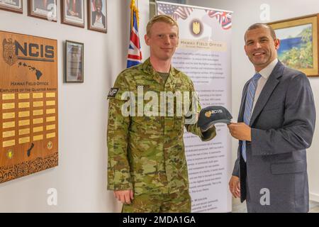 PEARL HARBOR (14 luglio 2022) Naval Criminal Investigative Service (NCIS) Special Agent Justin Smith, Right, regala il Capitano dell'esercito australiano Nicholas Wood con una palla all'ufficio NCIS sulla base congiunta Pearl Harbor-Hickam durante Rim of the Pacific (RIMPAC) 2022. Ventisei nazioni, 38 navi, quattro sottomarini, più di 170 aerei e 25.000 personale partecipano al RIMPAC dal giugno 29 al 4 agosto nelle isole hawaiane e nella California meridionale. Il più grande esercizio marittimo internazionale del mondo, RIMPAC offre un'opportunità di formazione unica, promuovendo e sostenendo la cooperazione Foto Stock