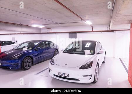 Bianco e blu Tesla Model 3 auto attendono la raccolta da parte dei proprietari, file di consegna sul parabrezza, Chatswood Sydney, Australia, sicuro nel parco sotterraneo Foto Stock