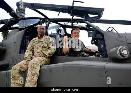 Brig. Il 14 luglio 2022 il generale Soo Park, sovrintendente della Republic of Korea Army Armor School, ha visitato la Brigata dell'aviazione di combattimento del 2nd per ricevere un brief sulle capacità dell'AH-64E V6 e dell'aquila grigia mq-1C. Brig. Il parco di genere si pone con il Chief Warrant Officer 2 akin Reynolds, un pilota di elicotteri Apache, nell'abitacolo dell'elicottero AH-64E Apache dopo aver ricevuto un'occhiata manuale dell'aereo. Foto Stock