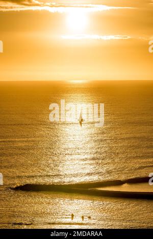 Tramonto su un'unica barca a vela al largo di Magic Island a Oahu, Hawaii Foto Stock