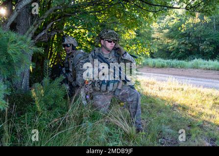 SGT. 1st Classe John Darhun di Alpha Company, 1st Battaglione, 114th reggimento fanteria, 44th Brigade Combat Team fornisce un aggiornamento della situazione via radio al suo comandante, mentre Sgt. Scott Divante tira la sicurezza prima di un movimento per contattare il trapano durante l'addestramento il 15 luglio, 2022 all'esercizio Exportable Combat Training Capability (XCTC) a Fort Drum, N.Y. Più di 2.500 soldati partecipano all'evento di addestramento, che consente alle squadre di combattimento delle brigate di raggiungere la preparazione del plotone addestrato necessaria per schierare, combattere e vincere. Foto Stock