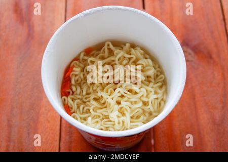 spaghetti istantanei bolliti, cuoci spaghetti istantanei in una tazza - zuppa di spaghetti su un recipiente di carta Foto Stock