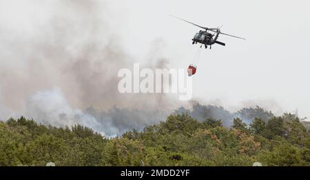 Una Guardia Nazionale dell'Oklahoma UH-60 Black Hawk si prepara a riempire il secchio dei Bambi attaccato per continuare a combattere un incendio selvaggio nella contea di Blaine, Oklahoma, il 16 luglio 2022. La Guardia Nazionale dell'Oklahoma ha assistito gli Oklahoma Forestry Services nel tentativo di controllare il blaze con l'uso di un falco nero UH-60. (Foto della Guardia Nazionale dell'Oklahoma di SPC. Pietra caleb) Foto Stock