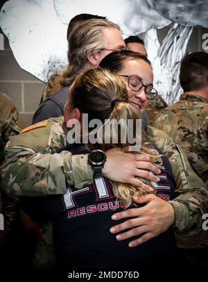 Un soldato della Guardia Nazionale dell'Esercito Iowa assegnato alla Società Medica 209th (supporto Area) abbraccia una persona amata dopo la conclusione di una cerimonia di mandata alla Clear Creek Amana High School di Tiffin, Iowa, il 16 luglio 2022. Alti dirigenti, famiglia e amici si sono riuniti in sala per onorare i 80 soldati che si stanno mobilitando in Polonia a sostegno dell'operazione Atlantic Resolve. Essi forniranno assistenza sanitaria agli ospedali da campo come parte della missione Enhanced Forward Presence della NATO, che consente agli Stati Uniti di fornire deterrenza agli avversari, sostenendo al contempo i nostri partner della NATO. Foto Stock