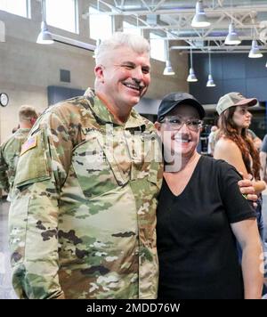 Un soldato della guardia nazionale dell'esercito dell'Iowa assegnato alla 209th Medical Company (Area Support) scatta una foto con una persona cara dopo la conclusione di una cerimonia di consegna alla Clear Creek Amana High School di Tiffin, Iowa, il 16 luglio 2022. Alti dirigenti, famiglia e amici si sono riuniti in sala per onorare i 80 soldati che si stanno mobilitando in Polonia a sostegno dell'operazione Atlantic Resolve. Essi forniranno assistenza sanitaria agli ospedali da campo come parte della missione Enhanced Forward Presence della NATO, che consente agli Stati Uniti di fornire deterrenza agli avversari, sostenendo al contempo i nostri partner della NATO. Foto Stock