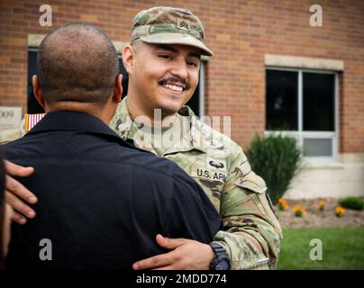 Un soldato della Guardia Nazionale dell'Esercito Iowa assegnato alla Società Medica 209th (supporto Area) abbraccia una persona amata dopo la conclusione di una cerimonia di mandata alla Clear Creek Amana High School di Tiffin, Iowa, il 16 luglio 2022. Alti dirigenti, famiglia e amici si sono riuniti in sala per onorare i 80 soldati che si stanno mobilitando in Polonia a sostegno dell'operazione Atlantic Resolve. Essi forniranno assistenza sanitaria agli ospedali da campo come parte della missione Enhanced Forward Presence della NATO, che consente agli Stati Uniti di fornire deterrenza agli avversari, sostenendo al contempo i nostri partner della NATO. Foto Stock