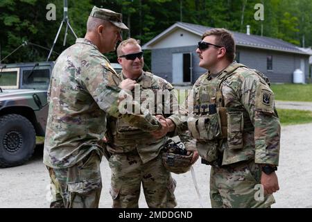 STATI UNITI Esercito Brig. Ralph Hedenberg, a sinistra, l'assistente generale, Connecticut Army National Guard, presenta una moneta agli Stati Uniti Matthew Yotka, a destra, un uomo di fanteria assegnato al battaglione del 1st, reggimento della fanteria del 102nd, guardia nazionale dell'esercito del Connecticut, durante una visita al campo di addestramento di Ethan Allen, Gerico, Vermont, 16 luglio 2022. Yotka ha ricevuto la medaglia per la sua performance come sergente del platoon durante il training annuale dei 102nd, dove ha svolto in un ruolo di due gradi salariali al di sopra del proprio, ha guidato due corsie di allenamento e ha sviluppato e raffinato platoon e comp Foto Stock