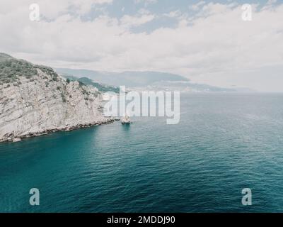 Foto aerea della roccia Parus Sail e Ayu-Dag Bear Mountain e vicino a Gaspra, Yalta, Crimea in una luminosa giornata di sole sul Mar Nero. Rock Parus a Gaspra Foto Stock