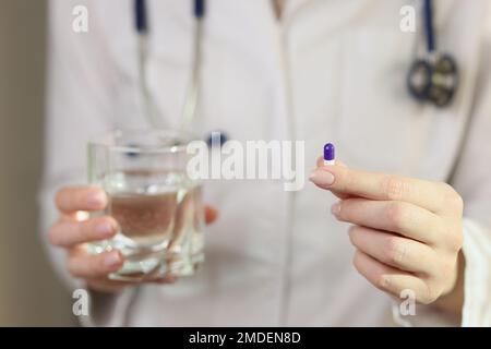 La dottoressa mostra una pillola nel suo primo piano della mano. Foto Stock
