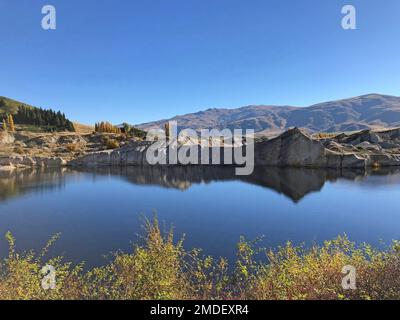 Spettacolare lago e scogliere create dai fanghi delle miniere d'oro, a St Bathans e il Lago Blu, Distretto di Maniototo, Nuova Zelanda Foto Stock