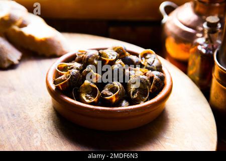 Tapa spagnola di lumache cotte al pepe in forno. Foto Stock