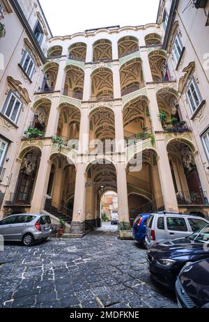 Lo stucco giallo e verde, gocciolante, scalinata curvilinea a Palazzo dello Spagnolo. Progettato dall'architetto barocco Ferdinando Sanfelice. A Napoli, Foto Stock