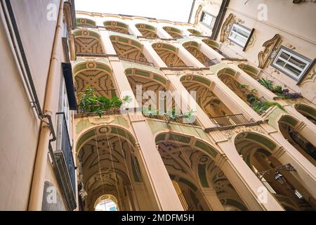 Lo stucco giallo e verde, gocciolante, scalinata curvilinea a Palazzo dello Spagnolo. Progettato dall'architetto barocco Ferdinando Sanfelice. A Napoli, Foto Stock