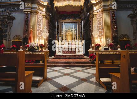 Vista frontale di un altare in una grande chiesa cattolica con panche o zampe di legno Foto Stock