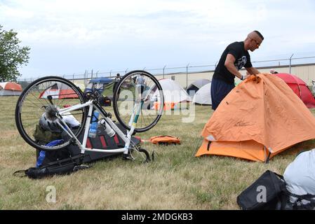 STATI UNITI Nicholas Ruiz, un ufficiale di integrazione di missione di STARCOM HQ, fissa una copertura di pioggia alla sua tenda alla 185th Air Refueling Wing a Sioux City, Iowa, 23 luglio 2022. Ruiz è membro della Air Force Cycling Team, che sta guidando nel 2022 Register’s Annual Great Bicycle Ride attraverso l’Iowa. Foto Stock