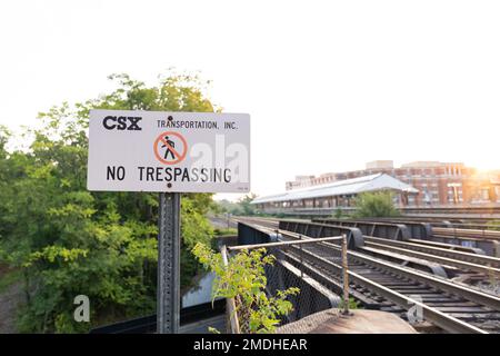 Un cartello di divieto di trasgressione davanti ai binari di CSX. Foto Stock