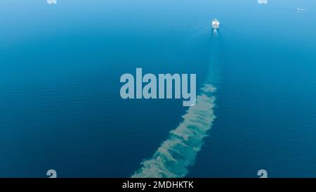 Contrail nell'oceano Stern dalla nave del contenitore del carico, nave marittima del carico con contrail nella nave dell'oceano che trasporta il contenitore e che funziona per l'esportazione c Foto Stock