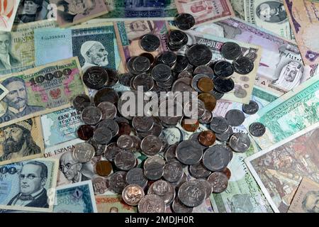 Vecchie monete americane di centesimi e dollari su varie vecchie banconote in denaro da diversi paesi del mondo, stack di valute multiple, mucchio Foto Stock