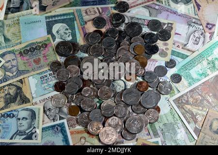 Vecchie monete americane di centesimi e dollari su varie vecchie banconote in denaro da diversi paesi del mondo, stack di valute multiple, mucchio Foto Stock