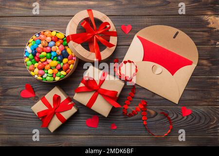 Busta rossa con caramelle e confezione regalo e cuori di San Valentino su  sfondo colorato. Piano di giacitura, vista dall'alto. Romantico lettera d' amore per il concetto di vacanza Foto stock - Alamy