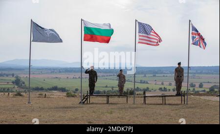 I soldati statunitensi, bulgari e britannici salutano la bandiera dei rispettivi paesi durante la cerimonia di apertura dell'esercizio Platinum Lion 22 presso la Novo Selo Training Area, Bulgaria, 25 luglio 2022. Alzare le bandiere significa la partecipazione bulgara, statunitense e britannica all'esercizio. Esercitazione Platinum Lion è un'esercitazione multinazionale ospitata in Bulgaria, progettata per migliorare l'interoperabilità operativa e tattica tra le nazioni partner partecipanti. Foto Stock