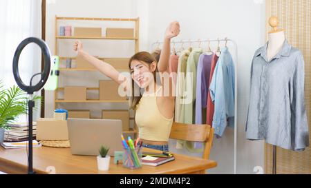 Concetto di vendita in linea, riuscito stilista delizioso con i vestiti di vendite effluenti in tensione. Foto Stock