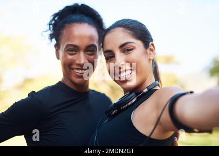 Ma in primo luogo, lascia prendere un selfie. Ritratto corto di due giovani donne attraenti in posa per un selfie dopo la loro corsa insieme nel parco. Foto Stock