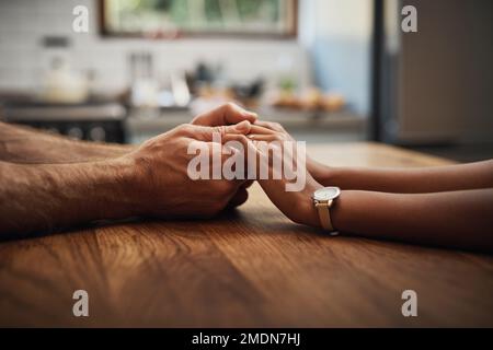 Ho bisogno di te al mio fianco. una coppia irriconoscibile che tiene le mani mentre siede insieme ad un tavolo. Foto Stock