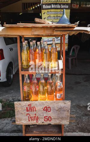 Benzina venduta in bottiglie di vetro usate su strada a Ko Lanta, Krabi, Thailandia. Novembre 29, 2022. Foto Stock