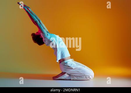 uomo che balla su sfondo giallo. Illuminazione al neon Foto Stock