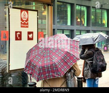 Glasgow, Scozia, Regno Unito 23rdt gennaio 2023. UK Weather: Pedone s alla fermata dell'autobus Wet ha visto la brolly ubiquitous apparire nel centro della città . Credit Gerard Ferry/Alamy Live News Foto Stock