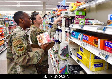 (Da sinistra a destra) Senior Airman Donald Lamar e Airman 1st Class Ella Valley, entrambi 75th Operational Readiness Medical Squadron, stock shelf al Commissary base 26 luglio 2022, alla base dell'aeronautica militare di Hill, Utah. Organizzato dal capitolo 1163 delle associazioni dei sergente dell'aeronautica, gli Airmen di tutta l'installazione hanno offerto volontariamente per rifornire gli scaffali nel deposito. Foto Stock