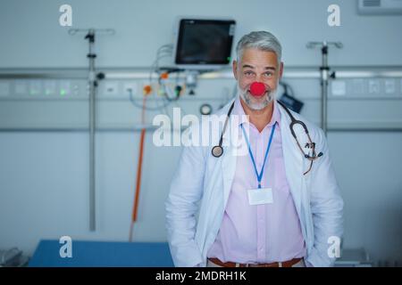 Ritratto di medico felice con naso rosso pagliaccio. Foto Stock