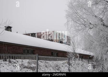 Fotografa in un'antica fabbrica, le pareti dell'arte Graffiti, i vecchi edifici industriali e il clima invernale gelido. Neve a terra Foto Stock