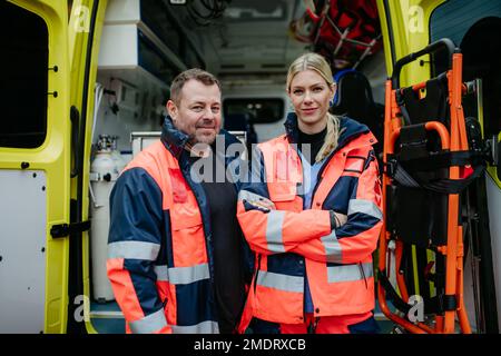 Ritratto dei soccorritori di fronte all'auto dell'ambulanza. Foto Stock