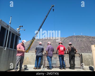 I membri dell’equipaggio operativi e di manutenzione della diga John Day, situata sul fiume Columbia vicino a Rufus, Oregon, guardano verso il basso nel blocco di navigazione della diga luglio 26 mentre gli ingegneri ispezionano il cancello a monte della serratura, che non funzionava a 25 causa di una ruota guida rotta. Mentre il corpo lavora per fissare il cancello verticale da 215.000 libbre, continua a passare le navi attraverso la serratura utilizzando una paratia galleggiante, un muro che può essere spostato dentro e fuori posto con un rimorchiatore e utilizzato essenzialmente come cancello temporaneo. Attualmente, gli armadietti delle navi, che in genere impiegano circa 45 minuti, impiegano il doppio della durata. Il Foto Stock