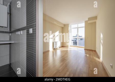 Stanza vuota con pavimenti in legno di quercia chiaro in una casa con una cucina senza porte Foto Stock