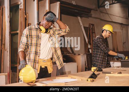 fatica stanca lavoratore duro lavoro in fabbrica di legno sudando tempo caldo Foto Stock
